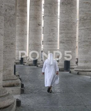 Nun walking through colonnade Stock Photos