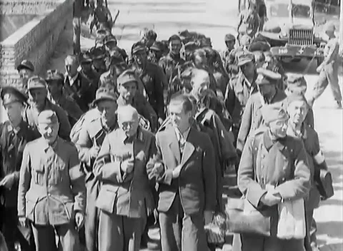 NUREMBERG - 1945: Clearing the city — Column of captured men passes trucks 库存影片 342919655