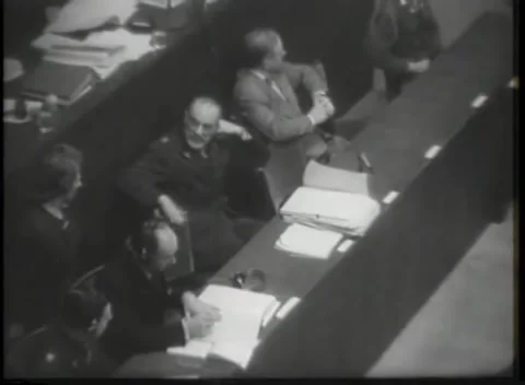 NUREMBERG - 1946: Seated men behind a panelled courtroom rail Stock Footage 342921106