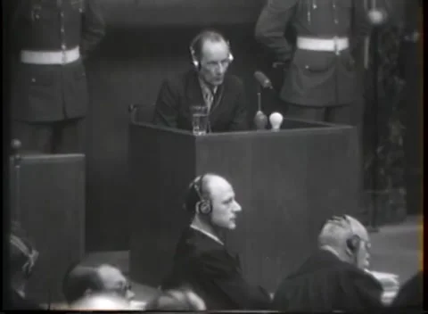 NUREMBERG - 1946: War crimes hearing — Bald listener below raised box Vidéo 343320854