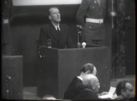 NUREMBERG - 1946: War crimes hearing — Holstered guard behind panelled box Video stock 343320880