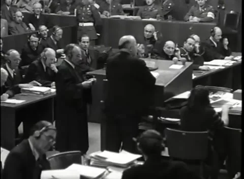 NUREMBERG - 1946: War Crimes Trials — Two robed figures at the counsel desks Stock Footage 342919910