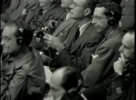 NUREMBERG - 1946: War Crimes Trials — A listener adjusts his headphone earpiece Stock Footage 342920123