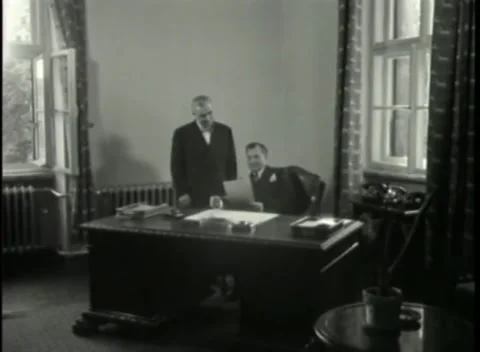 NUREMBERG - 1946: War Crimes Trials — White-haired visitor returns to the desk Stock Footage 342920344