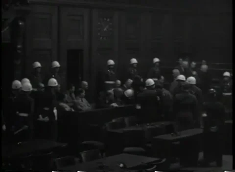 NUREMBERG, GERMANY - 1945: Assembly - Helmeted guards surround the dock end Stock Footage 344489677