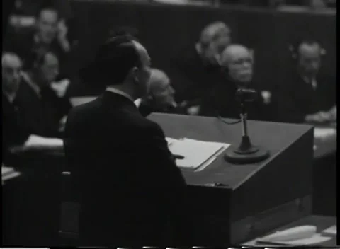 NUREMBERG, GERMANY - 1945: Headset - Speaker turns beside microphone and pages Stock Footage 344489613