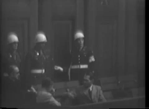 NUREMBERG, GERMANY - 1945: White web belts - Policemen stand over suited men Stock Footage 344901257