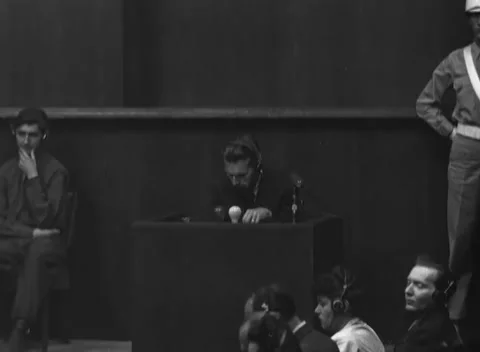 NUREMBERG, GERMANY - 1946: Dark box view - Witness bends over microphones 库存影片 343848248