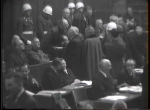 NUREMBERG, GERMANY - 1946: Dockside counsel - Robed group crowds enclosure rail 库存影片 343848125