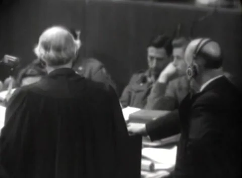NUREMBERG, GERMANY - 1946: Document stacks - Counsel face uniformed men Stock Footage 344901690