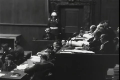 NUREMBERG, GERMANY - 1946: Evidence table - Witness sits beyond rolled files Stock Footage 344489488