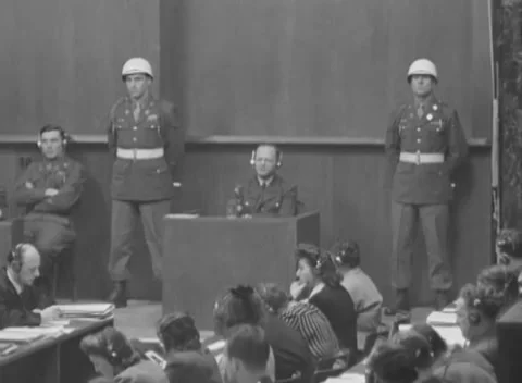 NUREMBERG, GERMANY - 1946: Folded arms - Helmeted guards flank witness box Stock Footage 344490383