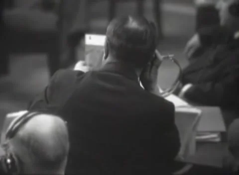 NUREMBERG, GERMANY - 1946: Headset - Listener presses wired receiver to ear 库存影片 344489170