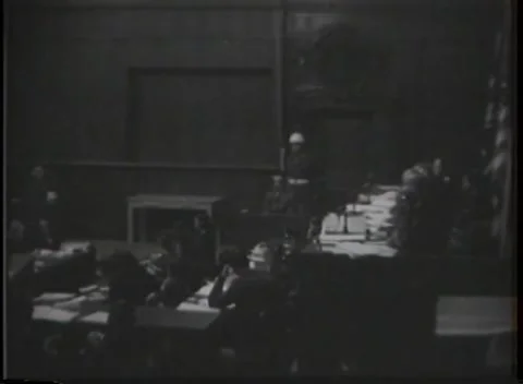 NUREMBERG, GERMANY - 1946: Paper stacks - Guard surveys packed courtroom 库存影片 344901505