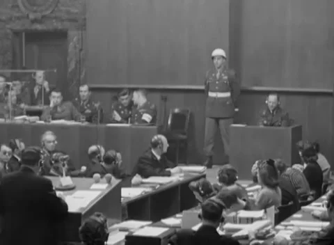 NUREMBERG, GERMANY - 1946: Paper study - Two dock occupants confer beside guard Stock Footage 344490316