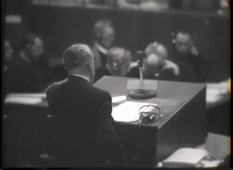 NUREMBERG, GERMANY - 1946: Shallow-focus study - Speaker beside desk microphone Stock Footage 344489973