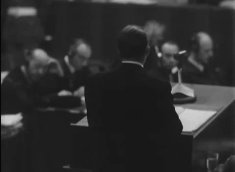 NUREMBERG, GERMANY - 1946: Shoulder study - Headset listener watches bench Stock Footage 344489436