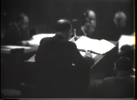 NUREMBERG, GERMANY - 1946: Silhouetted shoulders - Speaker addresses seated men Stock Footage 344901982
