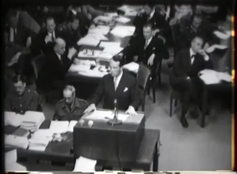 NUREMBERG, GERMANY - 1946: Table position - Suited figure stands at papers Stock Footage 343848446