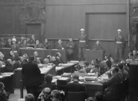 NUREMBERG, GERMANY - 1946: Table view - Files surround witness and dock guards Stock Footage 344490339