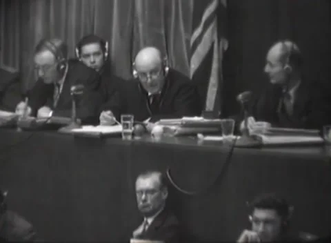 NUREMBERG, GERMANY - 1946: Tribunal - Robed judges write among documents 스톡 동영상 344489146