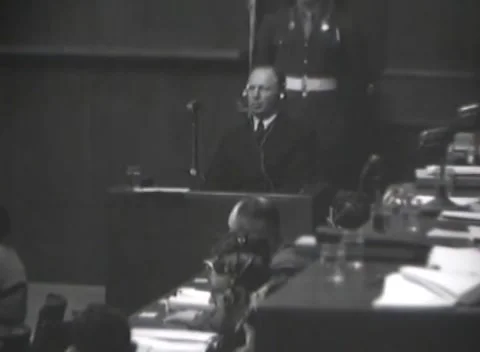 NUREMBERG, GERMANY - 1946: Turning man - Witness faces forward over long table 動画素材 344489334