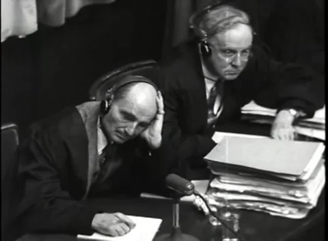 NUREMBERG, GERMANY - 1946: War Crimes Trials — Robed counsel in headphones Stock Footage 342818948