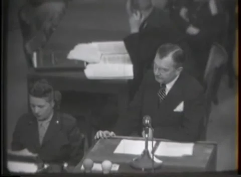NUREMBERG, GERMANY - 1946: War Crimes Trials — An arm across the document table Видео 342920908