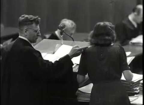 NUREMBERG, GERMANY - 1946: Woman's dark dress - Robed lawyer reads from paper Stock Footage 344902288