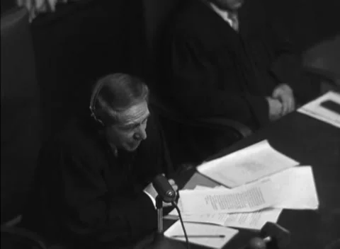 NUREMBERG, GERMANY - 1947: Arraignment — Hand rests on papers at the bench Stock Footage 343320797