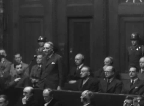 NUREMBERG, GERMANY - 1947: Enclosure - Dock speaker stands between two guards Stock Footage 344490699