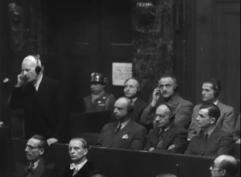 NUREMBERG, GERMANY - 1947: Layering - Headset listener stands beyond front bench Stock Footage 344490731