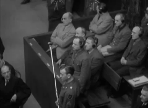 NUREMBERG, GERMANY - 1947: Observer - Headphoned men sit beside paper desk Stock Footage 344489043