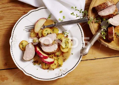 Nuremberg pork fillets with marjoram and apple wedges Stock Photos