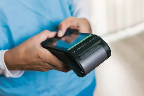Nurse accepting payment using contactless pos terminal Stock Photos