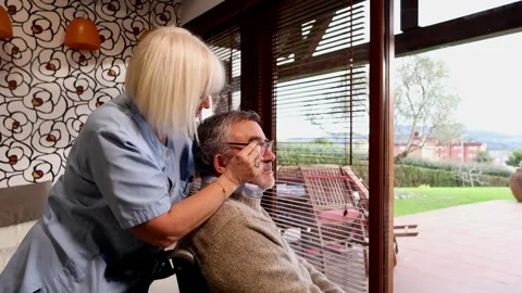 Nurse adjusting elderly man's glasses in wheelchair Stock Footage 300171004