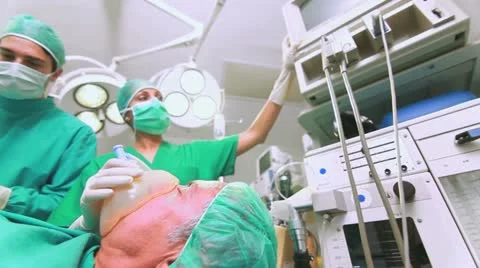 Nurse adjusting a monitor next to a patient Stock Footage
