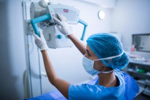 Nurse adjusting x-ray machine over patient Stock Photos