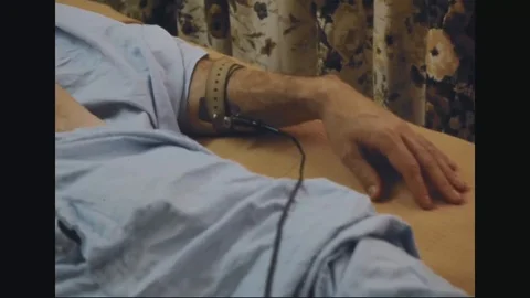 Nurse analyzes ECG electrocardiogram of a returned serviceman at hospital - 1973 Stock Footage 99916915