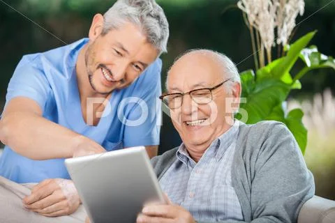 Nurse And Senior Man Enjoying While Using Tablet Computer