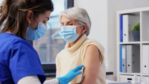 Nurse applying medical patch to vaccinated woman Stock Footage 168672673
