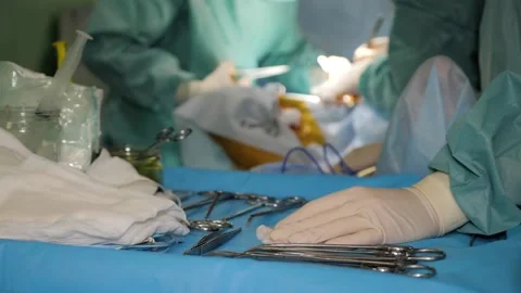 Nurse assisting doctors surgeons during surgical procedure in operating theater. Stock Footage