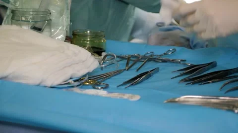 Nurse assisting doctors surgeons during surgical procedure in operating theater. Stock Footage 132496699
