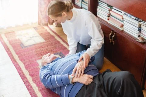 Nurse in assisting living program finding senior lying on the floor Stock Photos