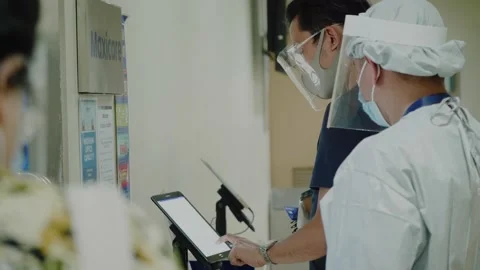 Nurse assists man  in queue for doctor's appointment in hospital in pandemic Stock Footage 153956223