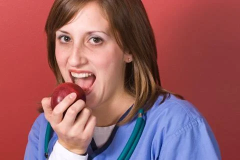 Nurse Biting An Apple Stock Photos