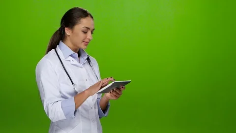 Nurse browses information on the tablet pc and cute smiles Stock Footage 70222891