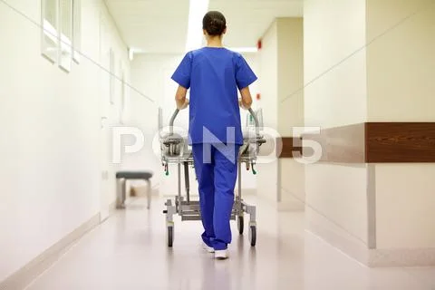 Nurse carrying hospital gurney to emergency room Stock Photos