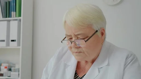 Nurse in charge working on computer at workplace. Video stock 299633048