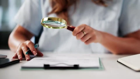 Nurse Checking Medical Codes And Bills Using Magnifying Glass Stock Footage 312472917